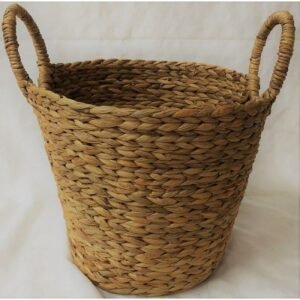 Canasto alto de fibra natural junto al sillón