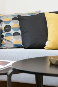 Contemporary living room interior featuring a stylish sofa, decorative pillows, and a vase of flowers.